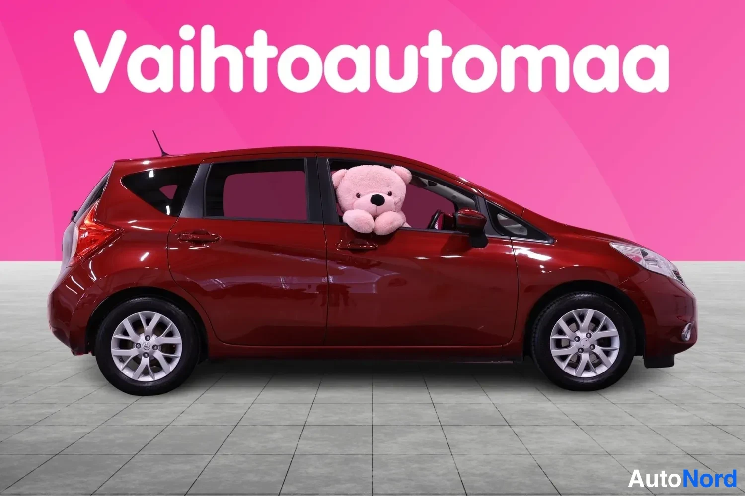 Sivulta: Tummanpunaisen Nissan Note -henkilöauton sivukuva oikealta puolelta.