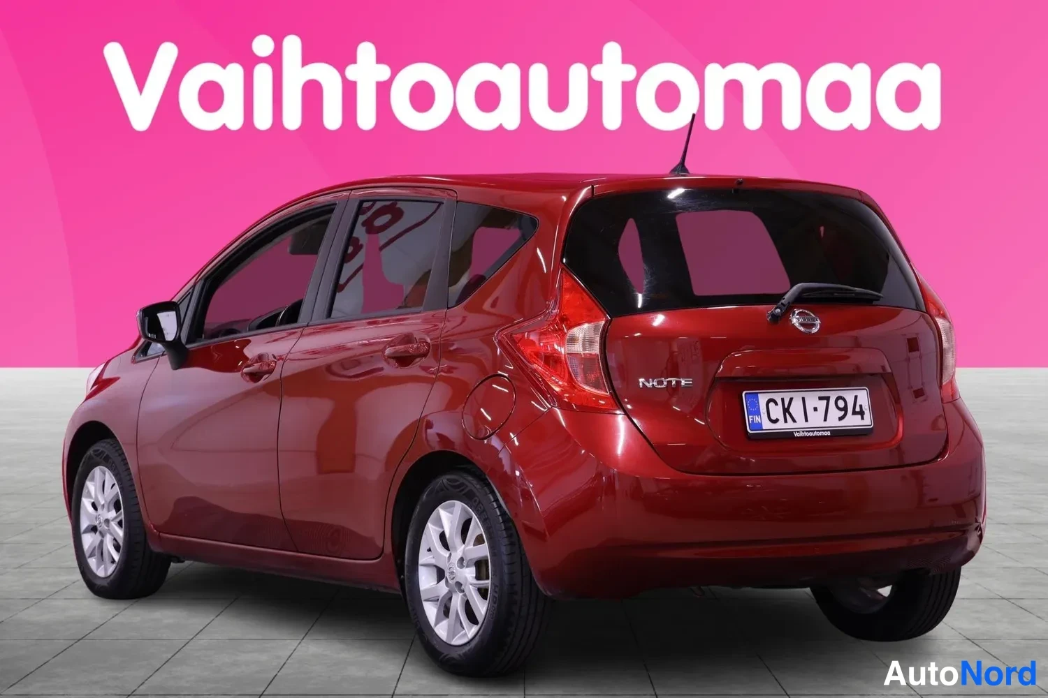 Takaviisto: Tummanpunainen Nissan Note kuvattu takaa vasemmalta viistosti; takaluukussa NOTE-merkintä ja rekisterikilpi.