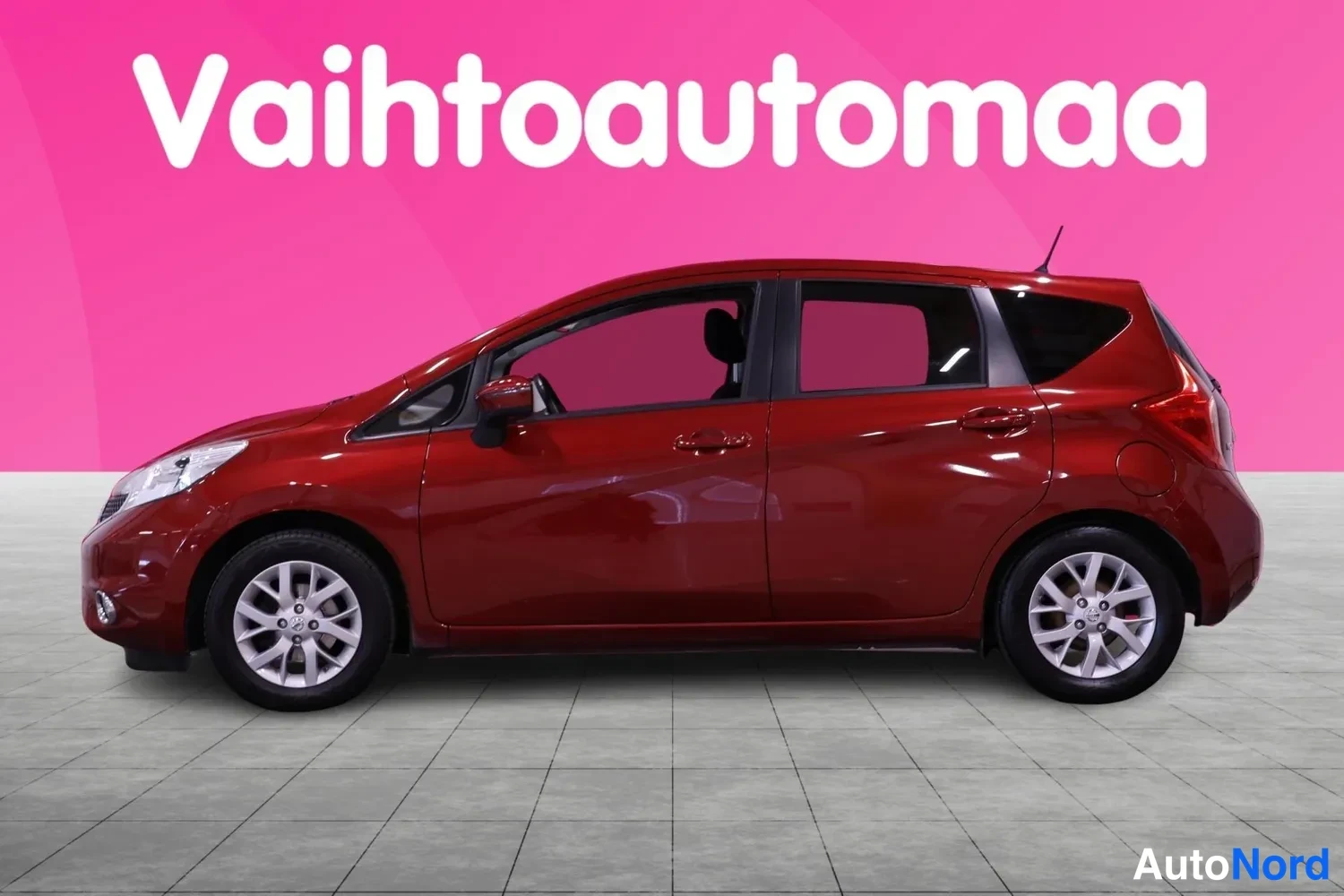Etuviisto, nokka vasemmalle: Tummanpunaisen Nissan Note -henkilöauton etukulmakuva