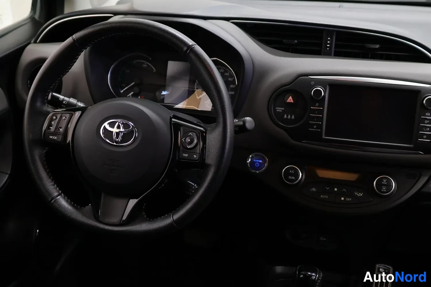 Muu: Ohjaamon kuvakaappaus: Toyota-ohjauspyörä, kosketusnäyttö ja ilmastointipaneeli.