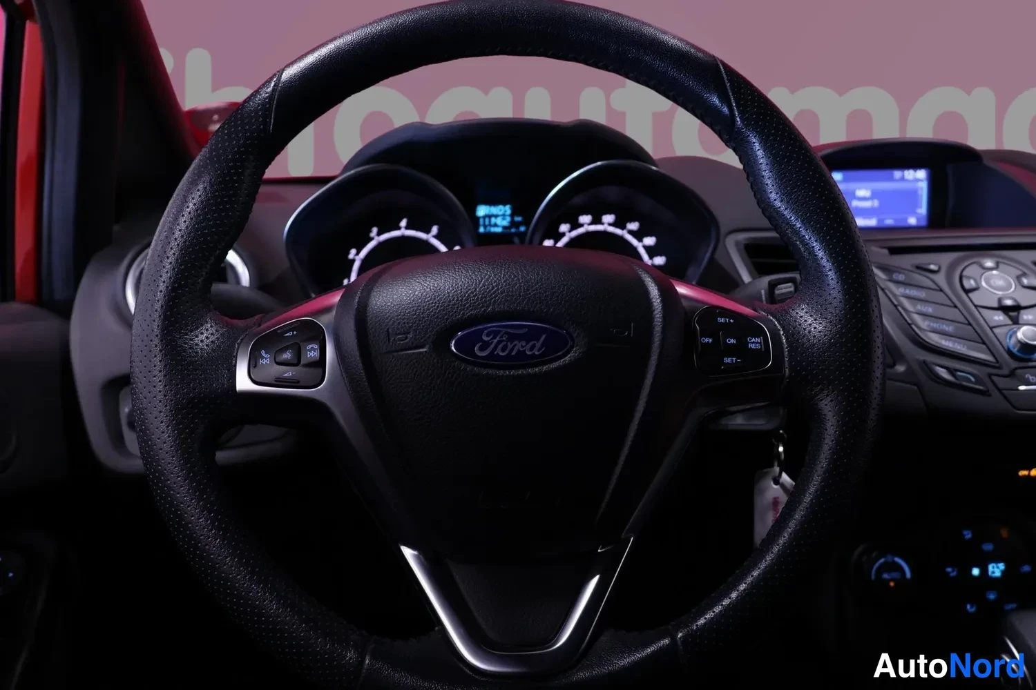 Muu: Tarkka kuva Ford-monitoimiohjauspyörästä, taustalla mittaristo ja keskikonsolin näyttö.