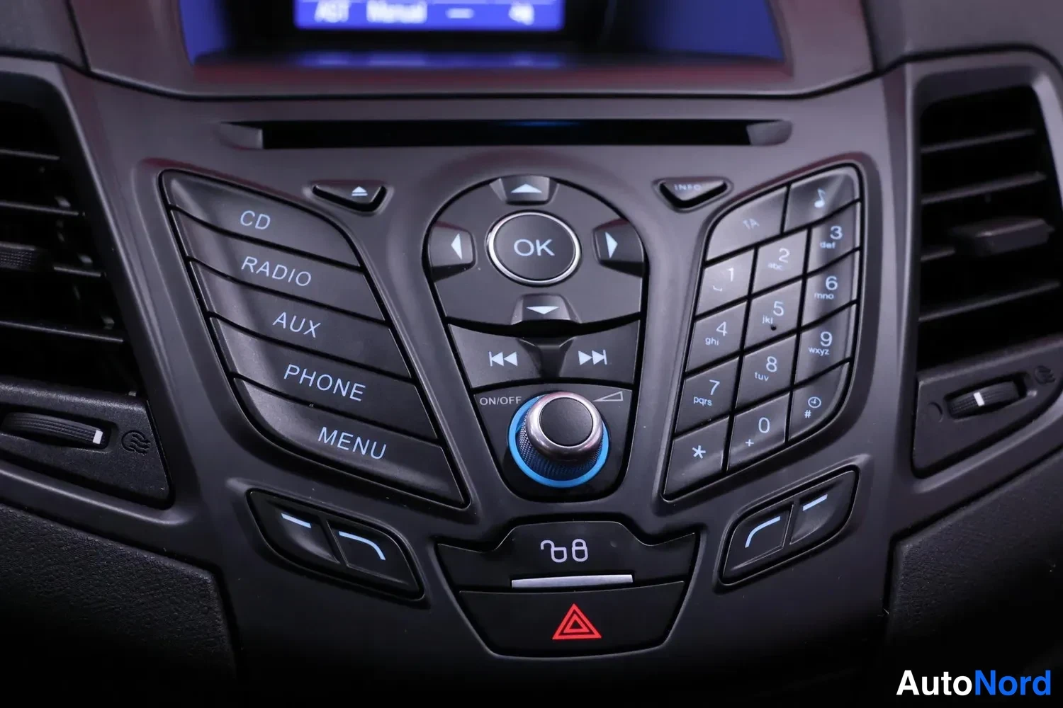 Muu: Keskikonsolin äänipainikkeet: CD, RADIO, AUX, PHONE, MENU ja numeronäppäimistö.