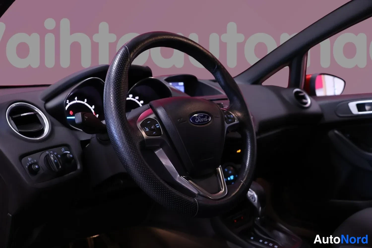 Muu: Ohjaamo näkyvissä: Ford-merkillinen monitoimiohjauspyörä, mittaristo ja kojelauta, tumma sisusta.