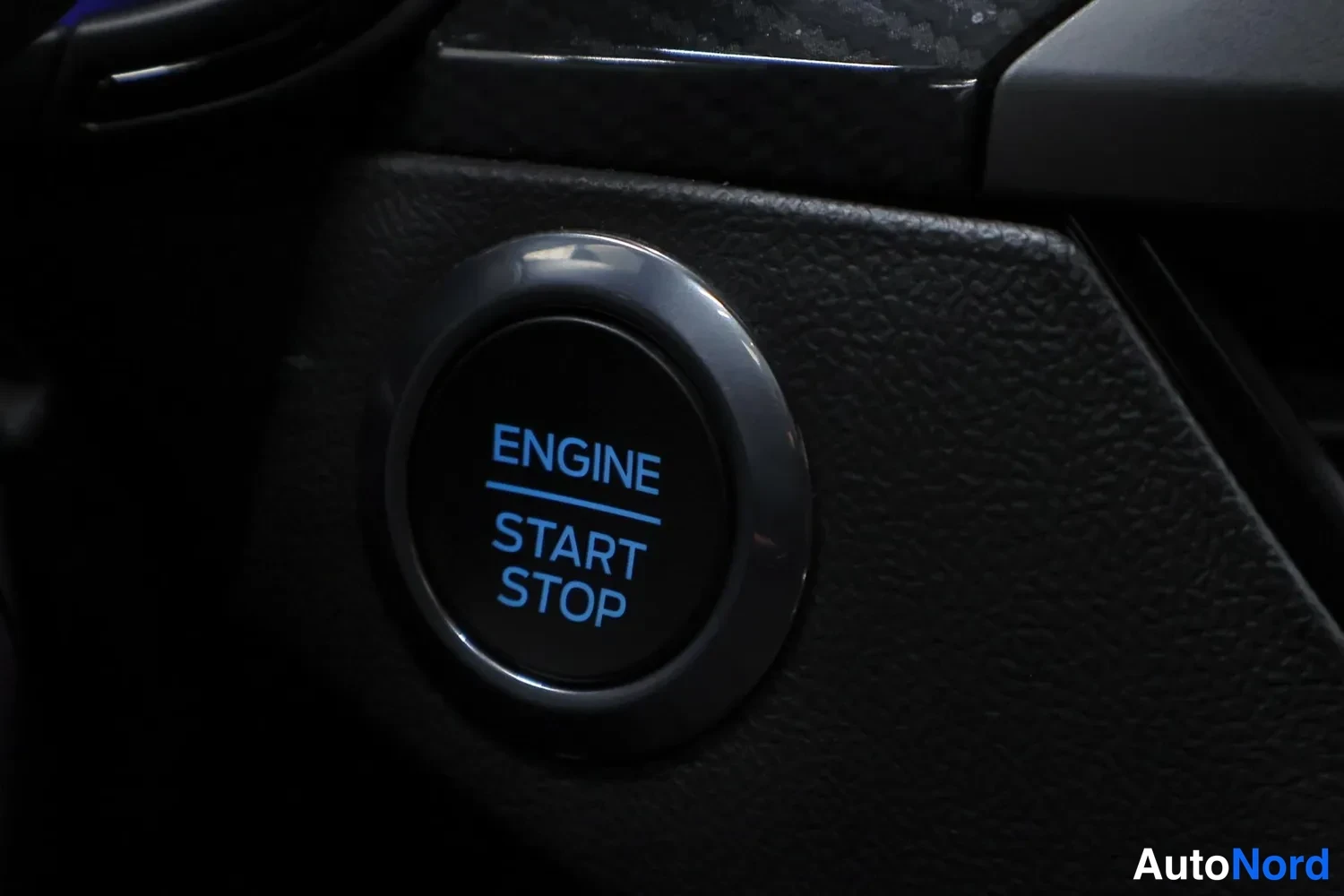 Yksityiskohta: Avoinkäynnistyspainike, jossa lukee ENGINE START STOP