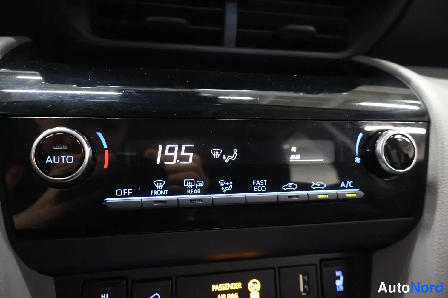 Yksityiskohta: Ilmastointipaneeli osoittaa lämpötilaksi 19,5 astetta; painikkeet OFF, FRONT, REAR, FAST ECO ja A/C sekä AUTO-ratkaisin näkyvät.