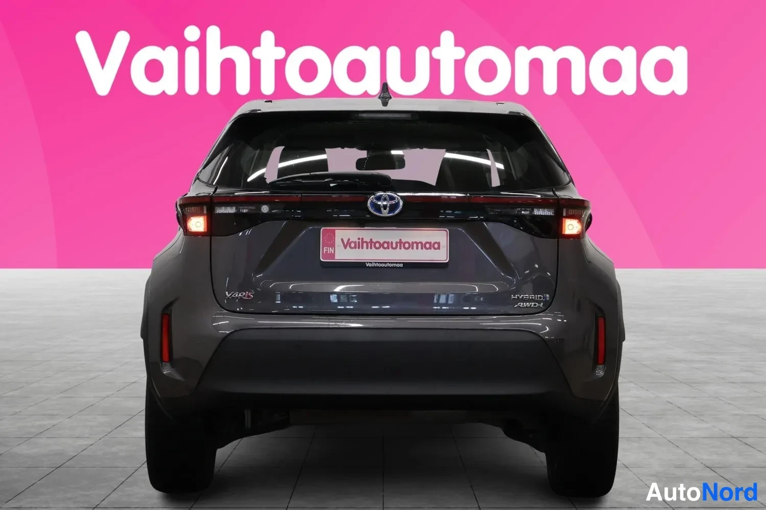 Takaa: Auton takaosan suora takaumasäkku, tummanharmaa kori, Toyota-merkki takaluukussa ja Vahtoautomaa-kyltti rekisterinpaikalla.