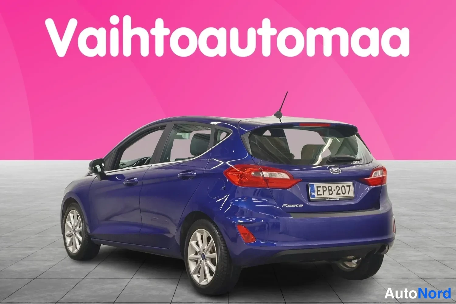 Takaviisto: Sininen viistoperäauto takaa oikealta kolmannesnäkymästä, rekisterikilpi ja Fiesta-merkintä.