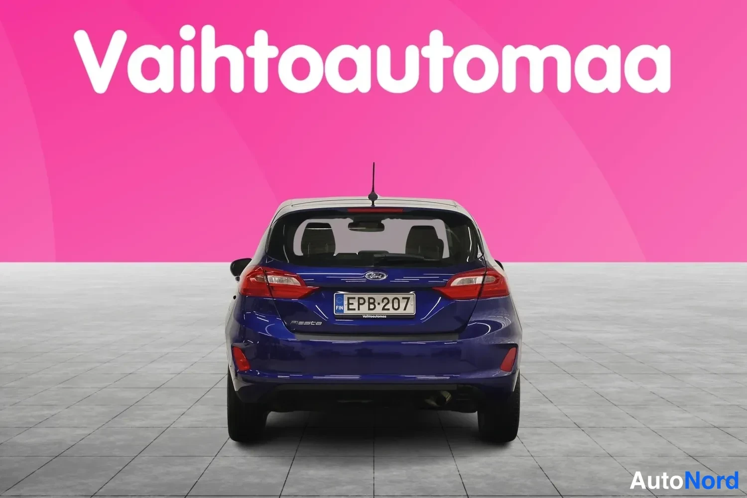 Takaa: Sininen viistoperäauto suoraan takaa, rekisterikilpi.