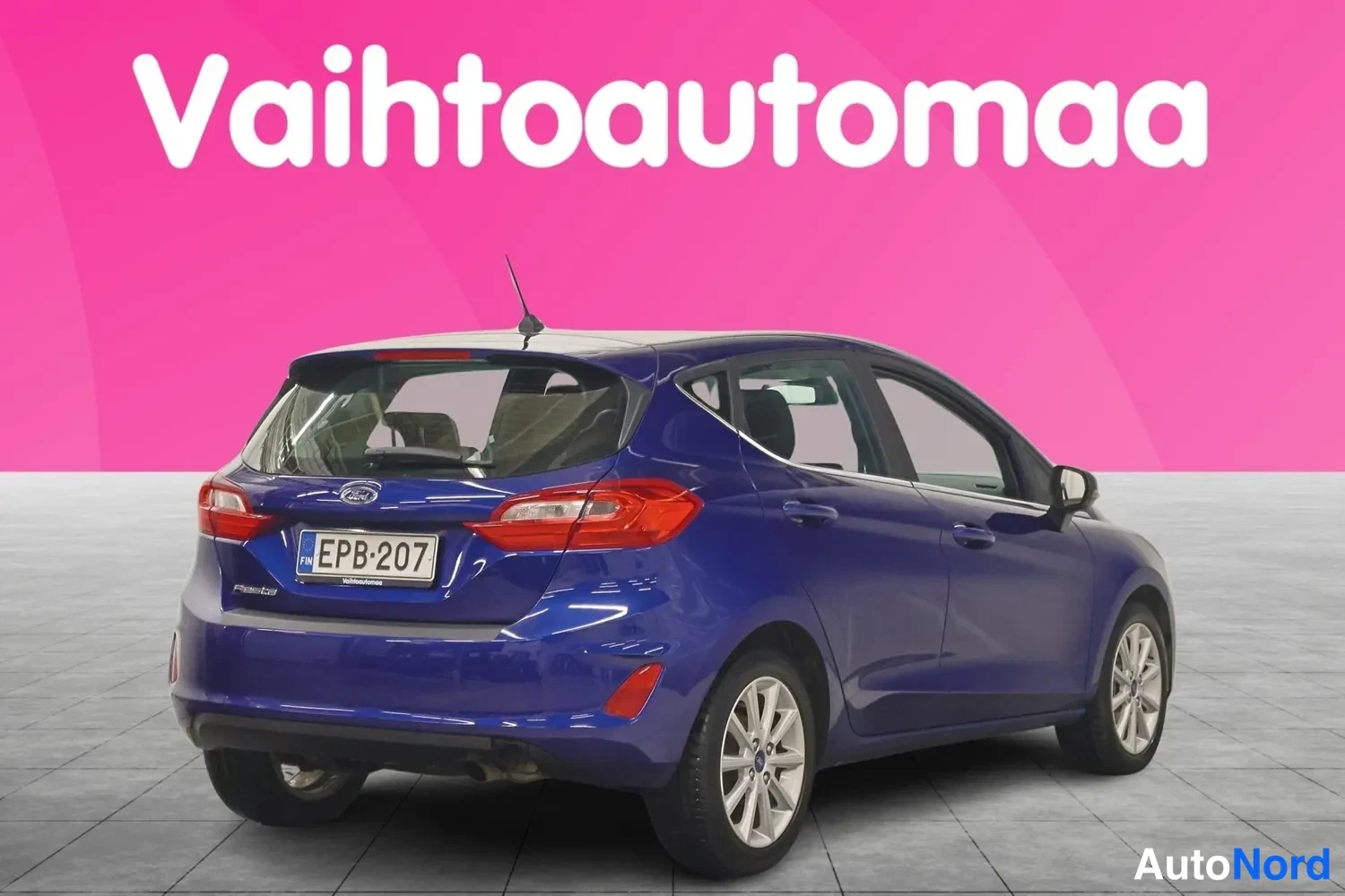 Takaviisto: Tummansininen Ford Fiesta kuvattu takakulmasta: takavalot, takaluukku ja vasen kylki näkyvissä, rekisterikilpi.