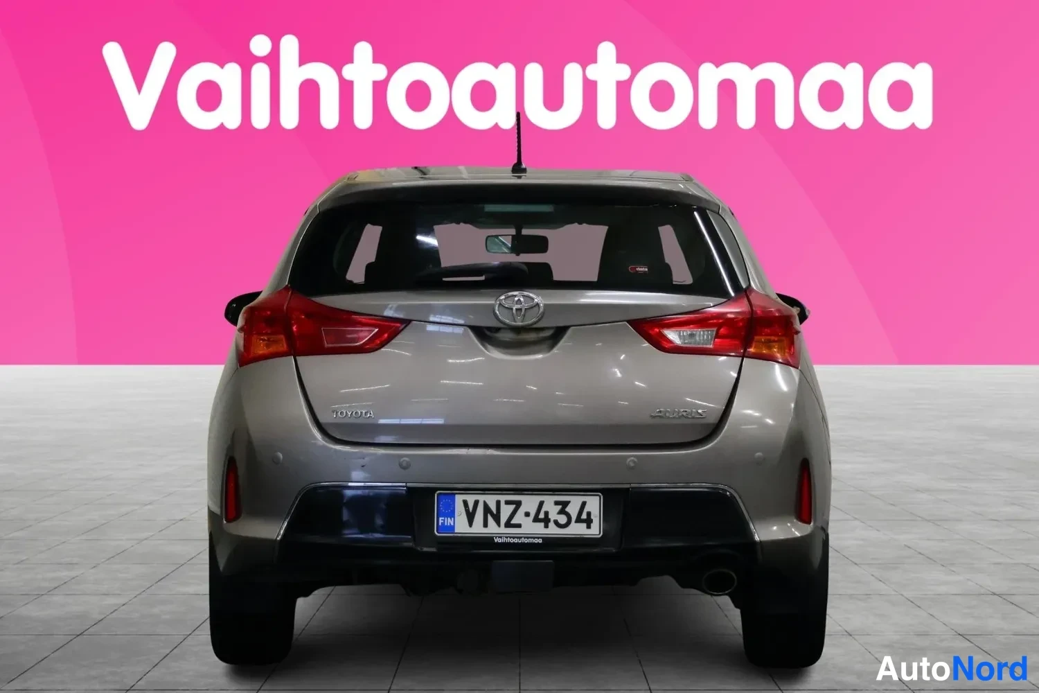 Takaa: Vaaleanharmaan Toyota Auris -henkilöauton takaosa suoraan takaa, rekisteritunnus.