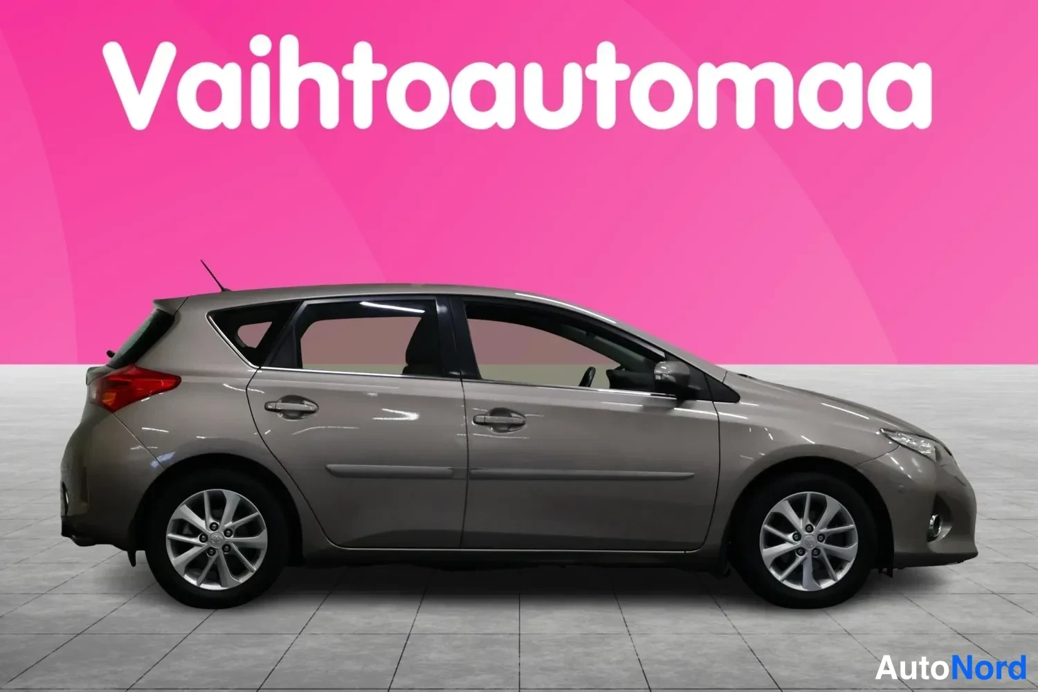 Sivulta: Toyota Auris 5-ovinen hatchback sivulta vasemmalta kuvattuna, tummanharmaa koriväri, hopeiset peltivanteet.