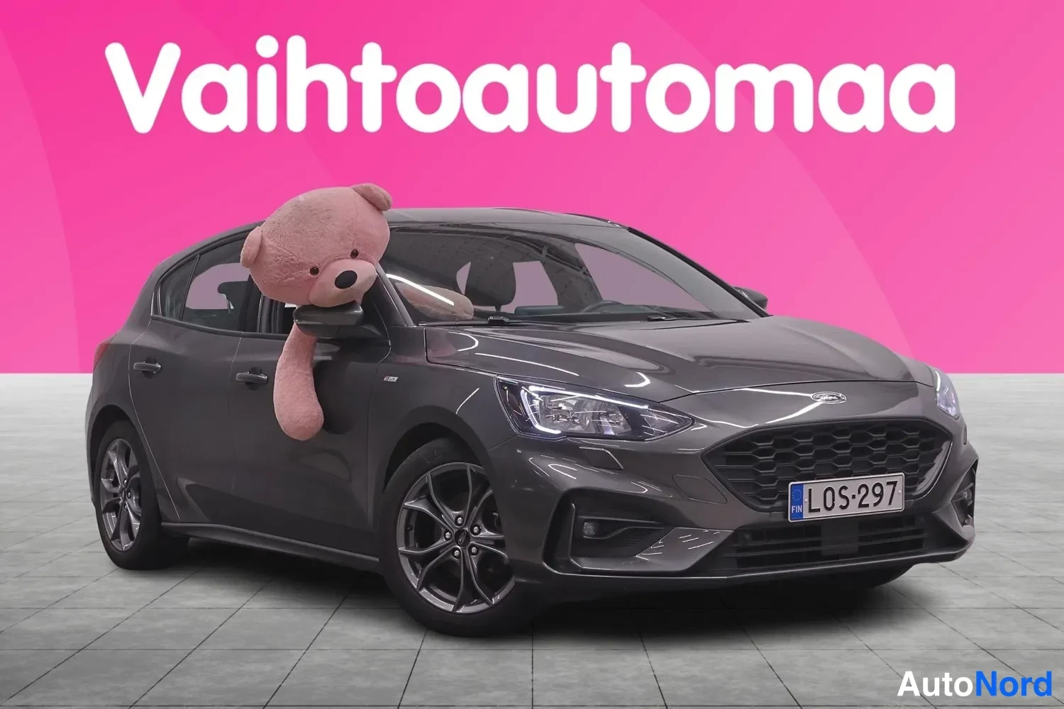 Etuviisto, nokka oikealle: Tummanharmaa Ford Focus -henkilöauto etuviistosta oikealta, rekisterillä, kuvattu myyntitilassa.