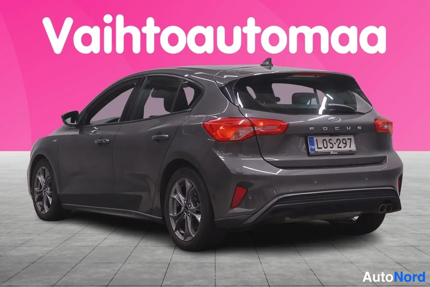 Takaviisto: Tummanharmaan Ford Focus -auton takapää kolmeneljänneksestä takaa, perässa FOCUS-teksti ja rekisterikilpi.
