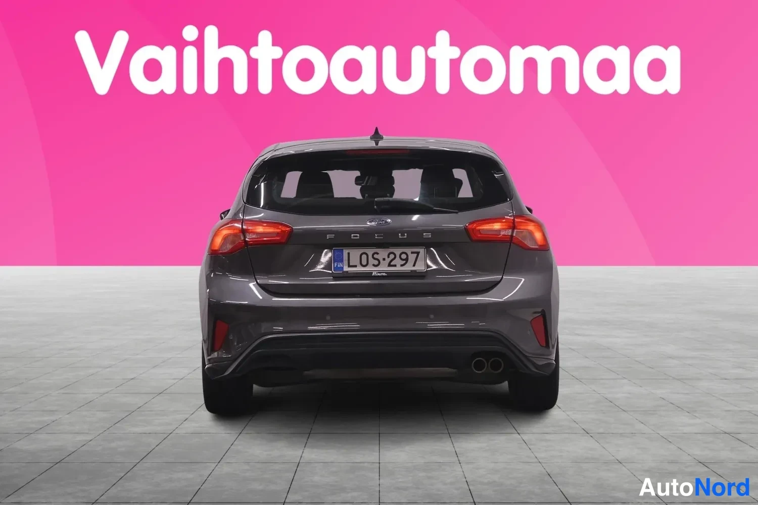 Takaa: Tummanharmaan Ford Focus -auton takaosa suoraan takaa, peräossa FOCUS-teksti ja rekisterikilpi.