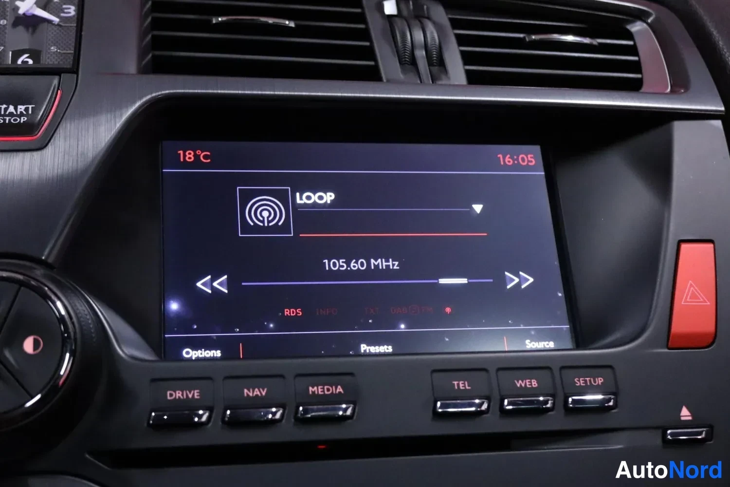 Yksityiskohta: Radio äänentoistolla: näytöllä 'LOOP' ja taajuus 105.60 MHz, lämpötila 18°C ja kellonaika 16:05.