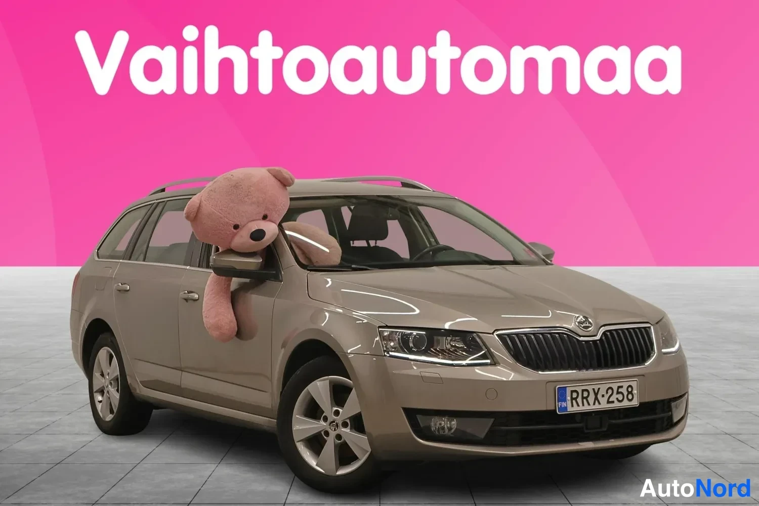 Etuviisto, nokka oikealle: Beige farmari edestä vasemmalta kuvattuna showroom-tyyppisessä kuvassa, rekisteritunnus.