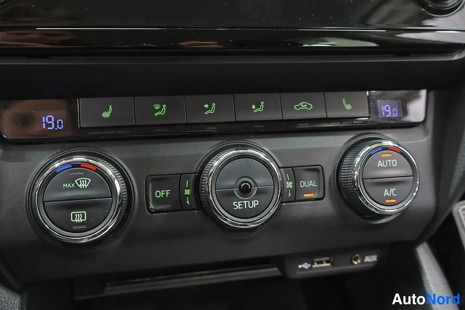 Muu: Ilmastoinnin ohjauspaneeli: AUTO, A/C, DUAL, OFF, SETUP, lämpötila 19,0, USB- ja AUX-liitännät.