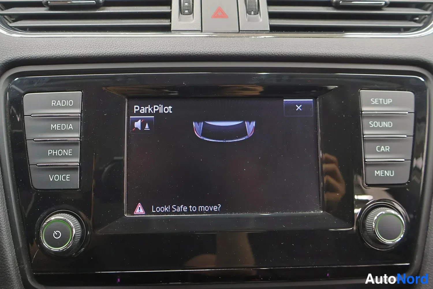 Yksityiskohta: Radiovaihtimen näyttö näyttää ParkPilot-ruudun tekstillä 'ParkPilot' ja 'Look! Safe to move?'.