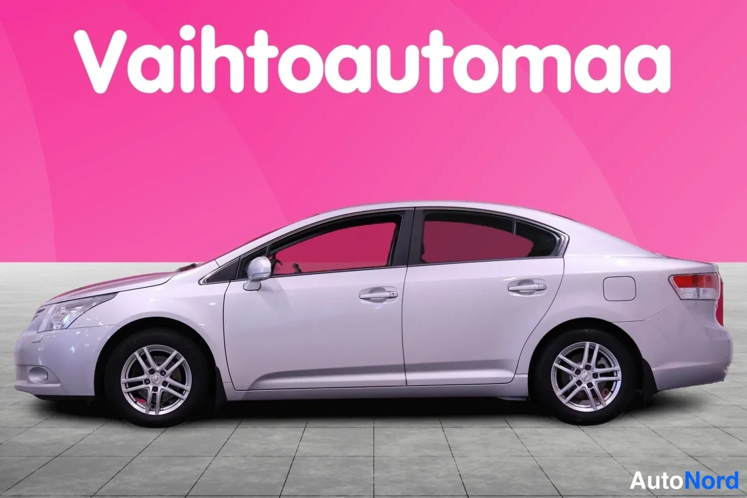 Sivulta: Toyota Avensisin sivukuva, hopea sedan molemmat sivut näkyvät osittain.
