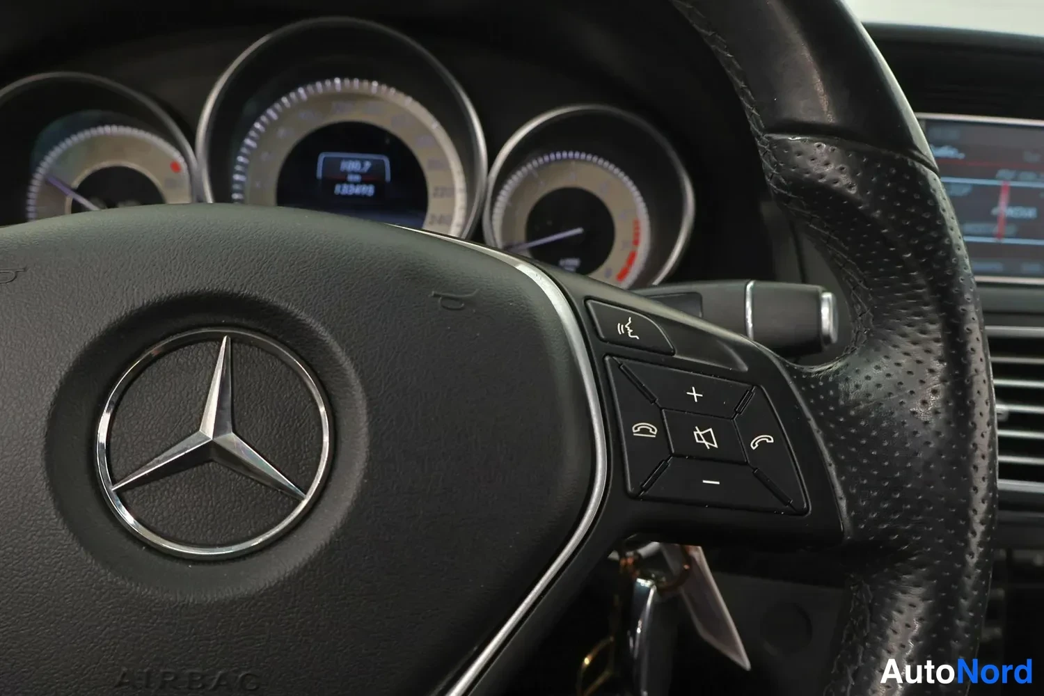 Yksityiskohta: Rattitarkkuus ja kojelauta, mittaristo ja Mercedes-tähti näkyvissä.