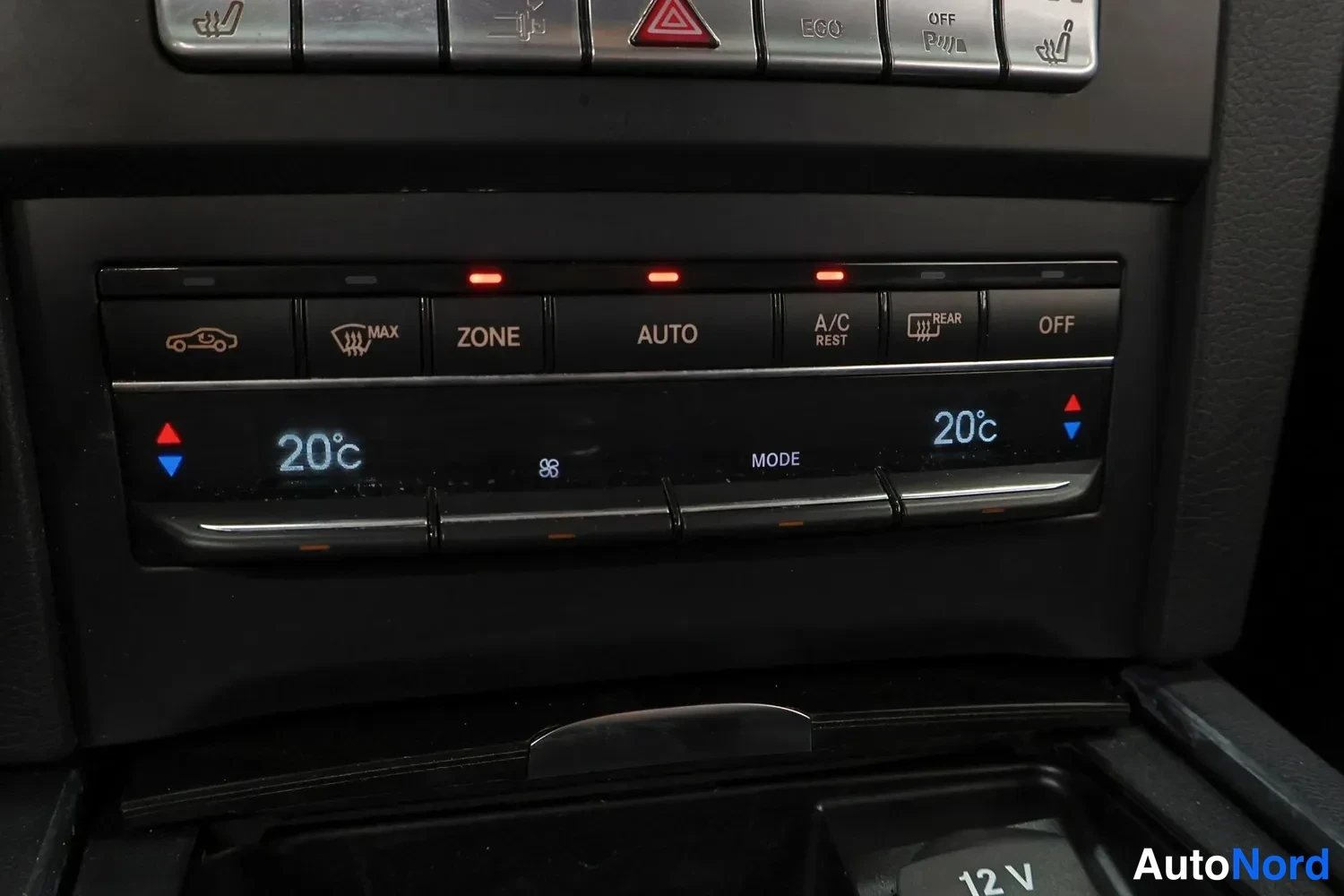 Yksityiskohta: Ilmastointipaneeli näyttää 20 °C molemmin puolin; napit AUTO, ZONE, A/C REST ja OFF näkyvissä.