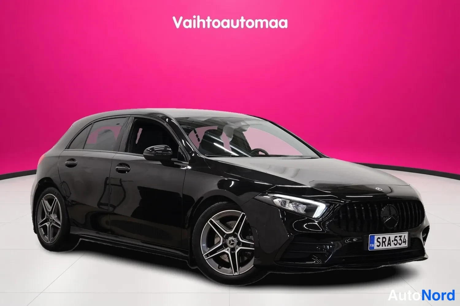 Etuviisto, nokka oikealle: Musta Mercedes-Benz A-luokan viistosti edestä oikealta kuvattu farmikori... ei, viistosti edestä, keula oikealla.