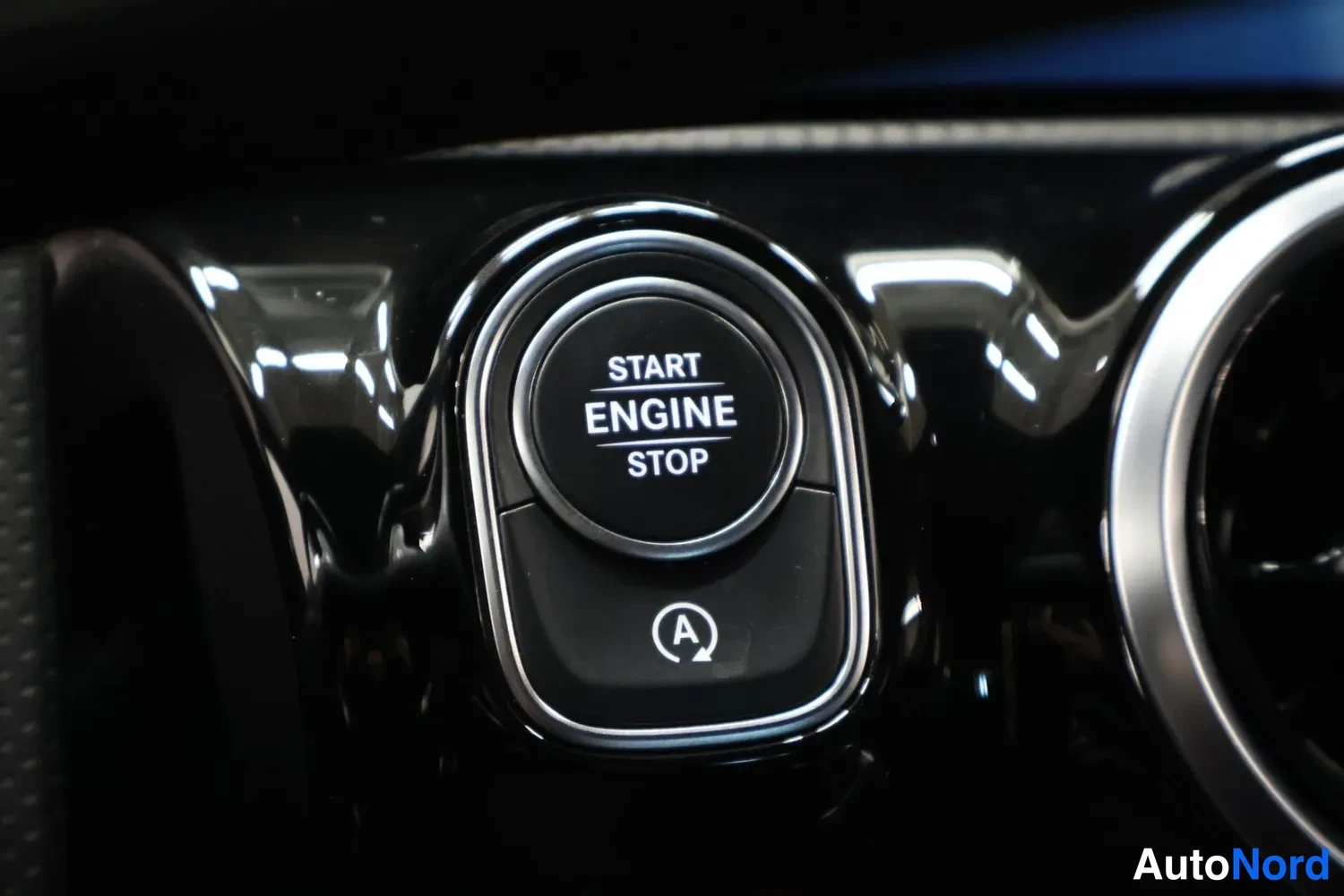 Yksityiskohta: Kojelaudan start-stop-nappi, teksti START ENGINE STOP.