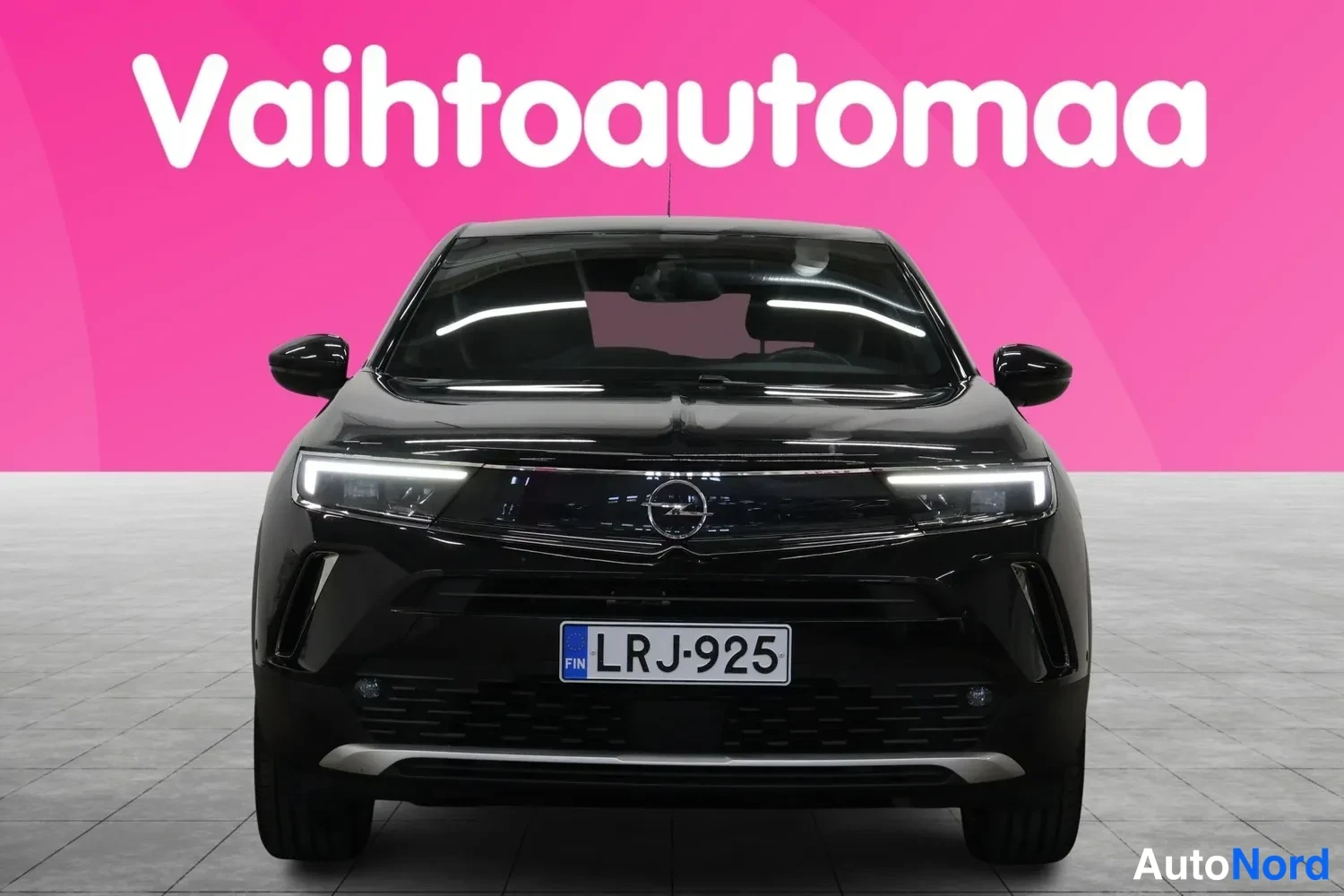 Edestä: Mustan auton suora etunäkymä, jossa näkyy Opel-merkki etusäleikössä, LED-ajovalot ja rekisterikilpi FIN.