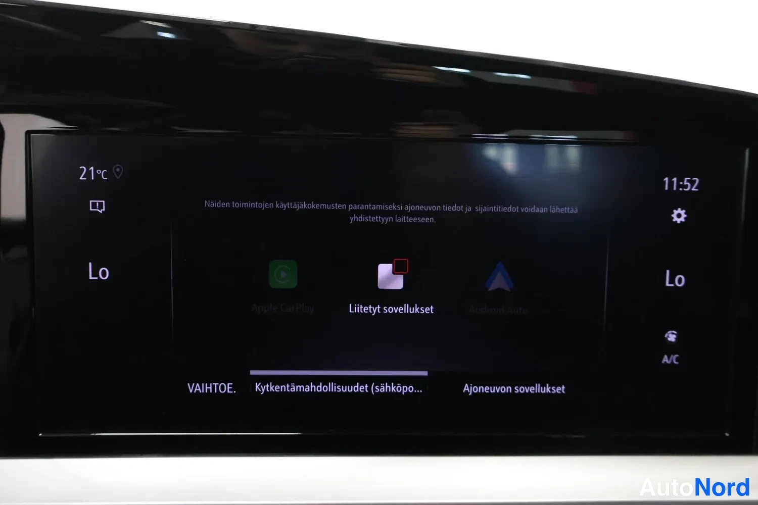 Muu: Auton kojelaudan kosketusnäyttö näyttää liitettyjen sovellusten valikkoa, jossa ovat Apple CarPlay ja Android Auto -kuvakkeet. Näytön alareadassa valikot VAIHTO