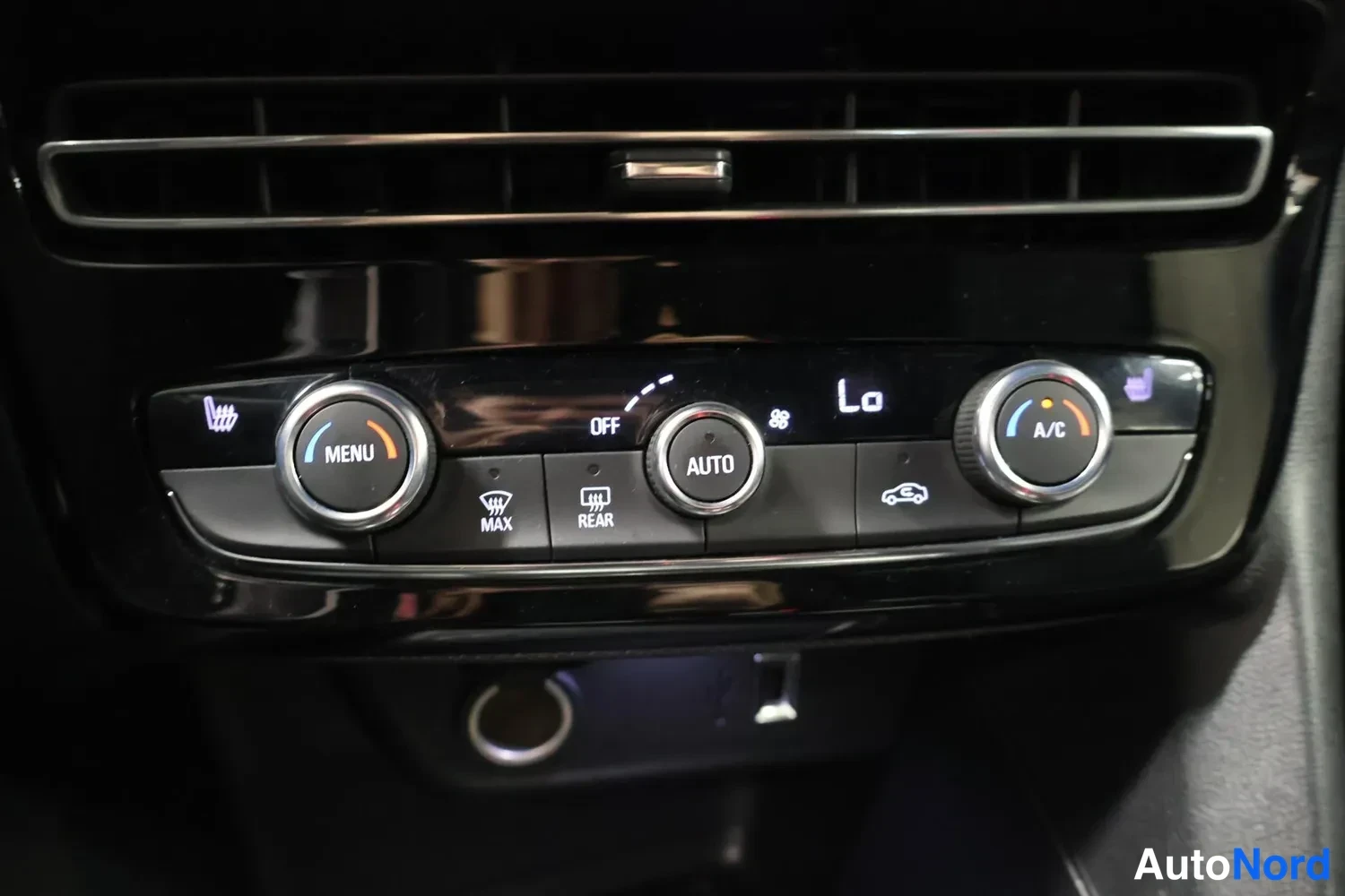 Muu: Auton automaattinen ilmastointipaneeli: MENU-nuppi vasemmalla, OFF/AUTO-liukunuppi keskellä ja A/C-nuppi oikealla. Lisäksi napit MAX, REAR, LM-merkki, Lo-merkki