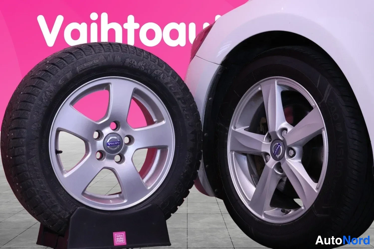 Muu: Kaksi Volvo-kevytmetallivannetta renkaineen lähikuvassa, taustalla auton valkoinen kori.