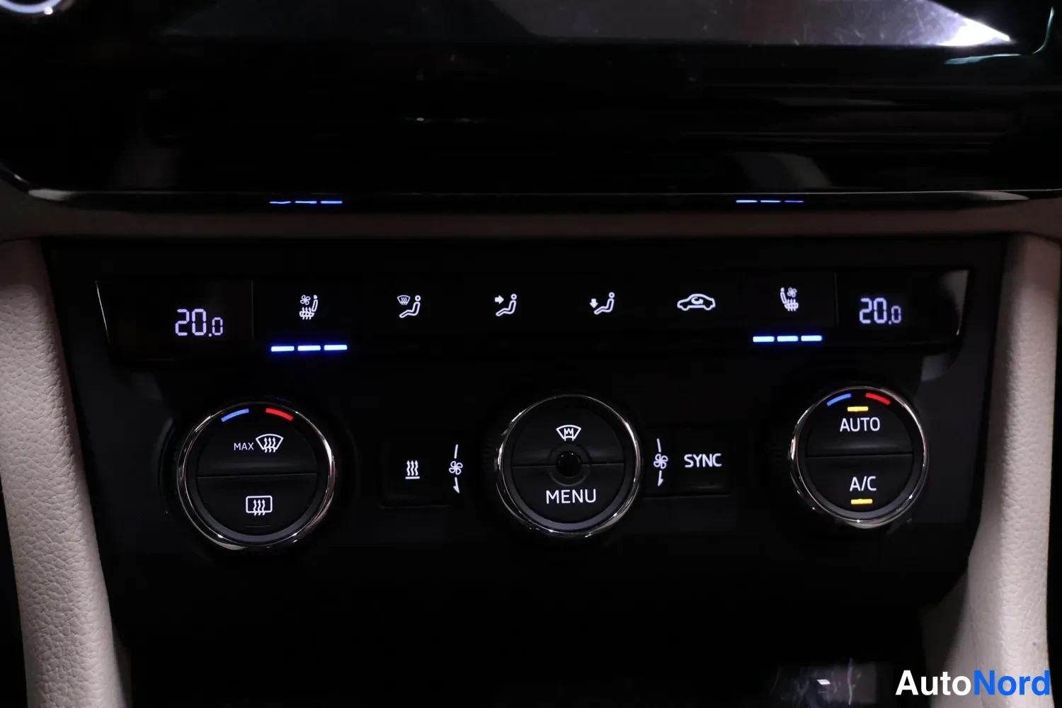 Yksityiskohta: Kojeiston ilmastointipaneeli näytöillä 20.0, napit AUTO, A/C, SYNC ja MENU.