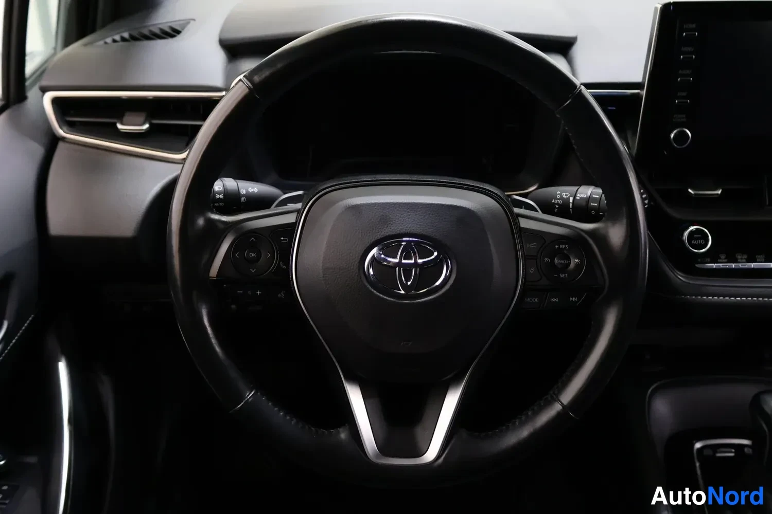 Muu: Ohjaamon mitattu kuva: Toyota-merkkinen ohjauspyörä, kojelauta ja osa keskikonsolista.