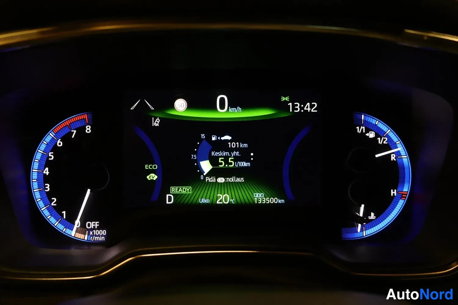 Muu: Mittariston lähikuva: hybridi-Ready-merkki, kilometrilukema 133500 km, D-vaihde, ulkolämpötila 20 °C ja keskimääräinen kulutus 5,5 l/100km.