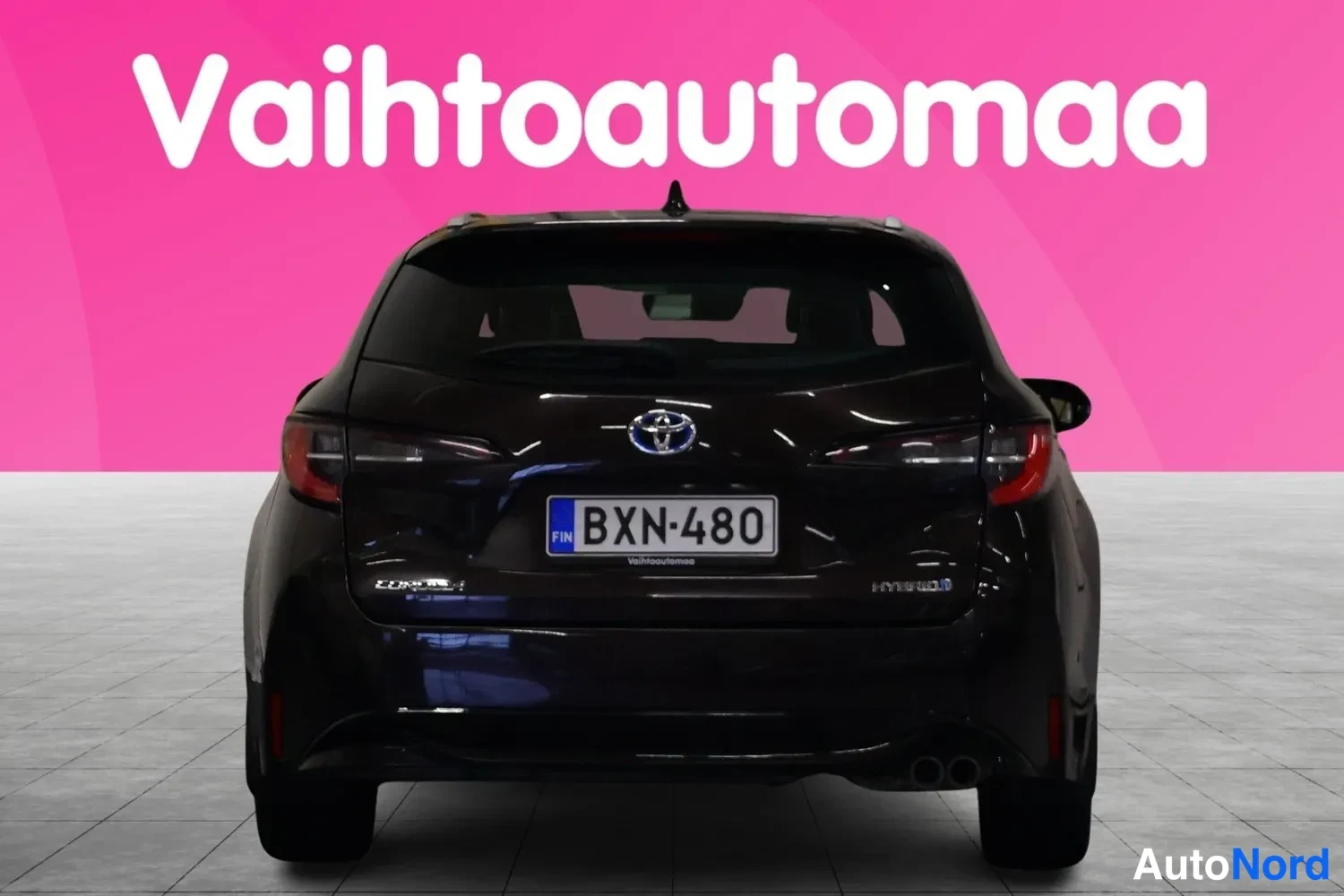 Takaa: Mustanruskean Toyota Corolla Touring Sports -farmarin takaosa suoraan takaa, rekisterikilpi.