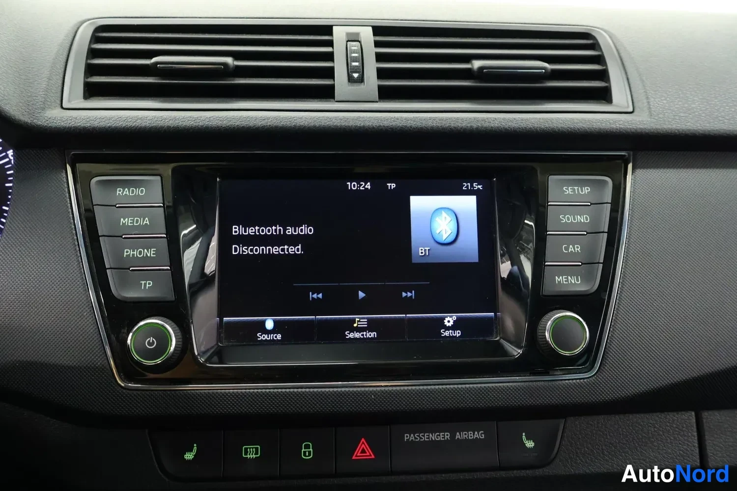 Muu: Kojeiston keskuskonsoli: näytöllä teksti 'Bluetooth audio Disconnected.' ja BT-kuvake, kellonaika 10:24 ja lämpötila 21,5°C. Ympärillä RADIO-, MEDIA-, PHONE-, T