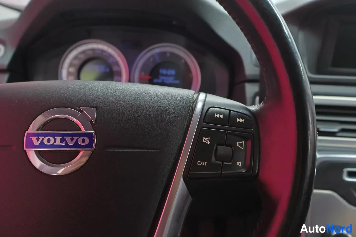 Yksityiskohta: Volvo-ohjauspyörä ja kojelauta lähikuvassa.