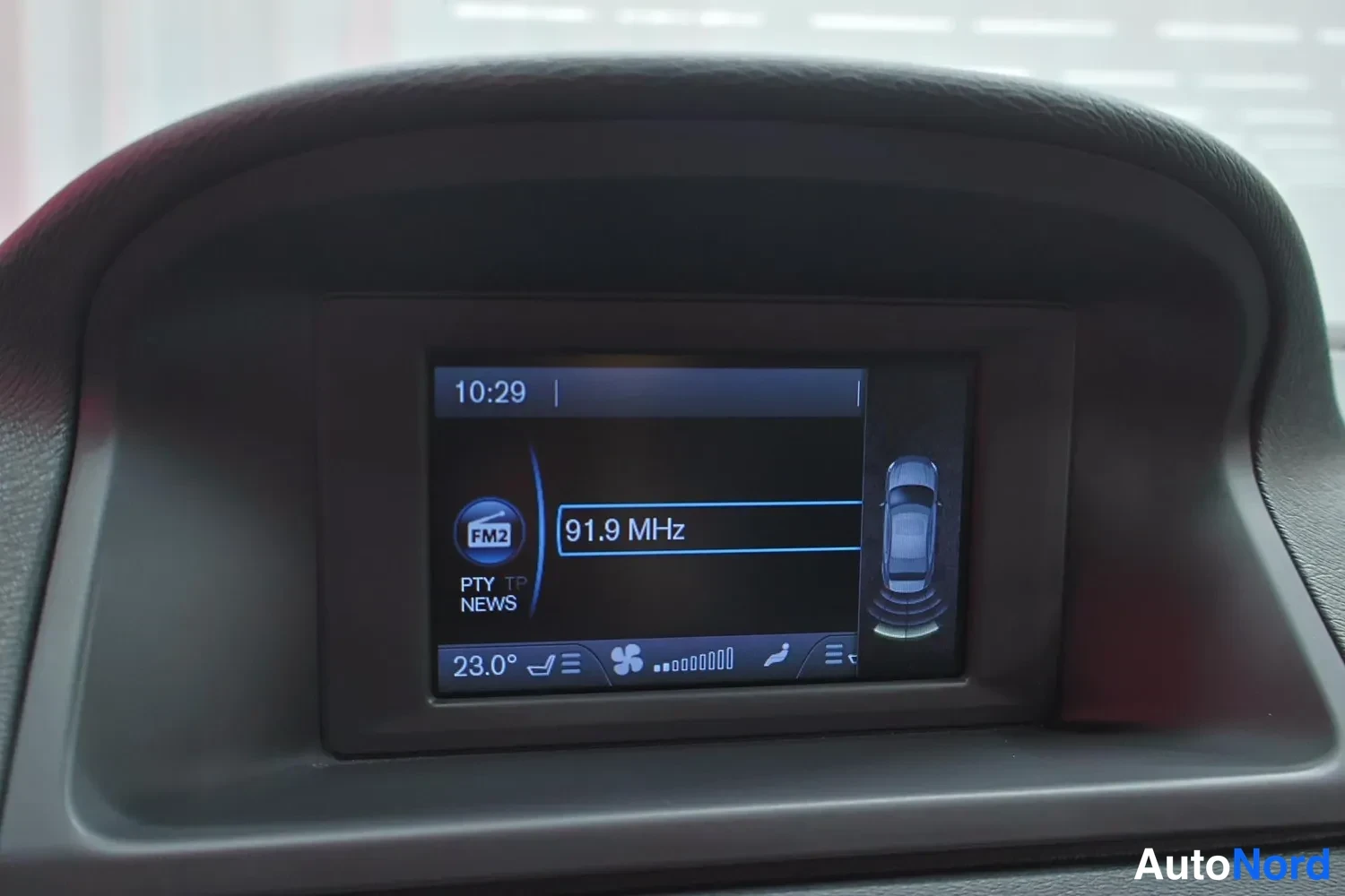 Yksityiskohta: Kojeiston infotainment-näyttö: FM2 91,9 MHz, kello 10:29, lämpötila 23,0 astetta.
