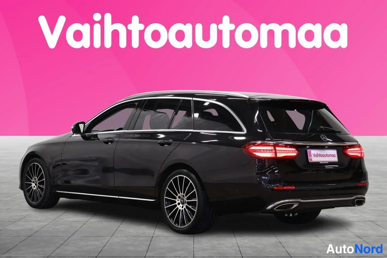 Takaviisto: Mustan farmaritavan Mercedes-Benzin takaosa ja vasen kylki valokuvastudioassa, LED-takavalot ja kromista pakosarjan pääte näkyvät.