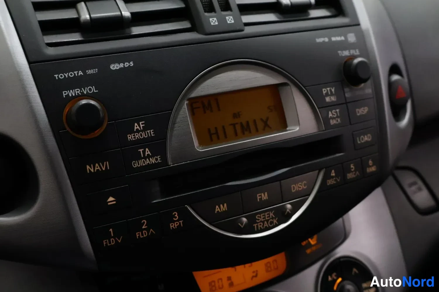 Muu: Toyotan radio- ja CD-yksikön lähikuva näytössä tekstillä FM1 HITMIX, napit NAVI, TA, AF ja LOAD näkyvissä.