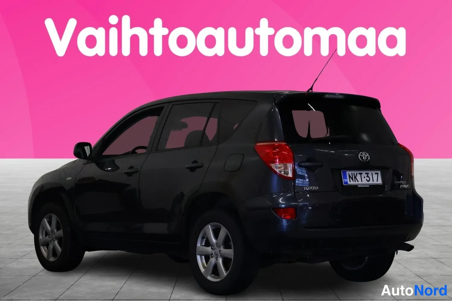 Takaviisto: Toyota RAV4 takakolmestedestä oikealta, tummansininen kori, rekisteri, Toyota-merkintä takaluukussa.