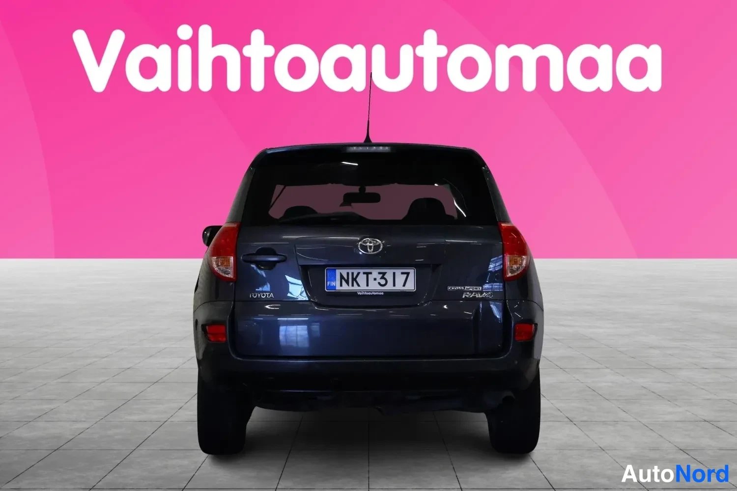 Takaa: Toyota RAV4 suoraan takaa päin, tummansininen kori, rekisteri, korkea kolmas jarruvalo.