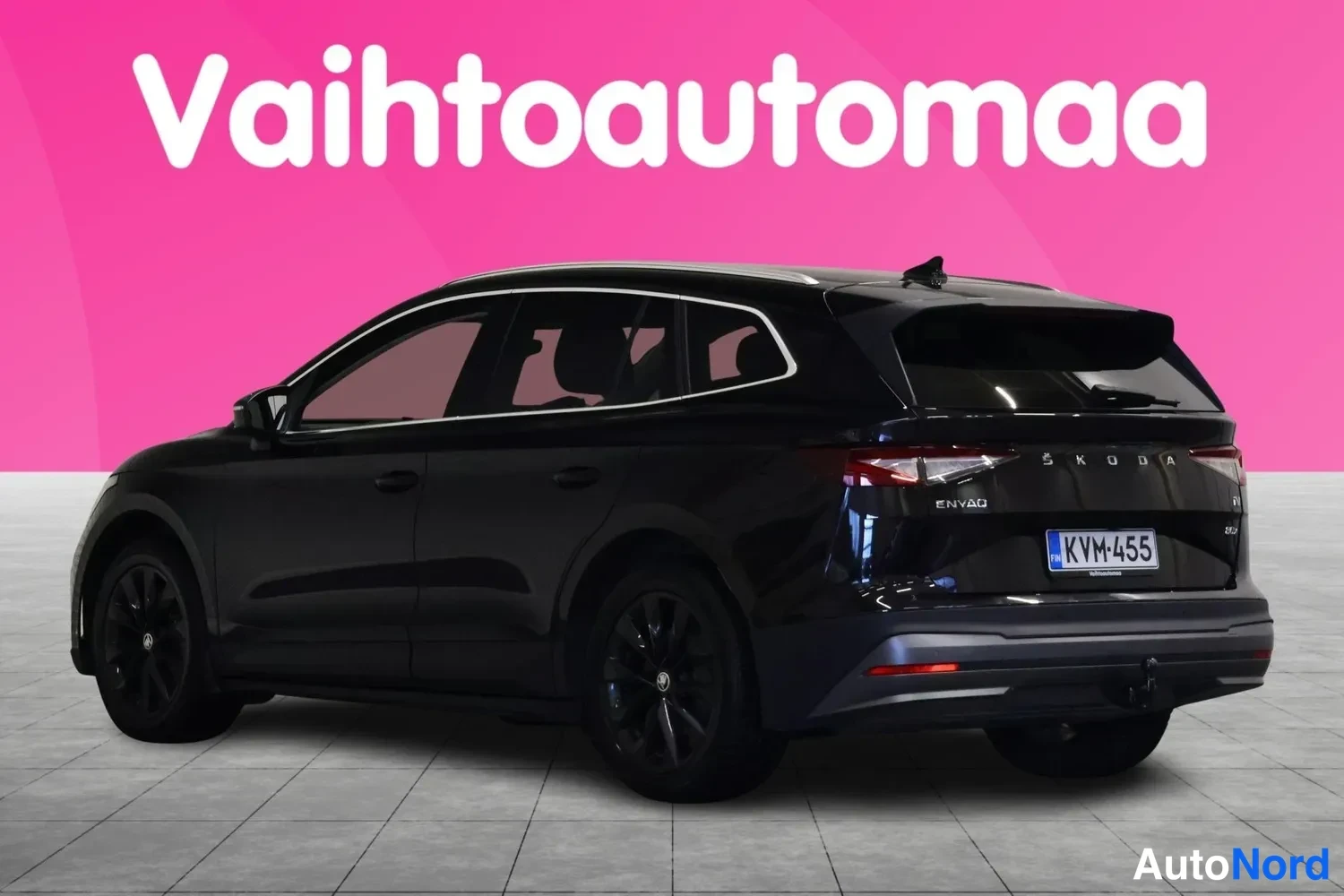 Takaviisto: Musta Skoda Enyaq takaviisto vasemmalta, SKODA- ja ENYAQ-tekstit sekä rekisterikilpi takaluukussa.