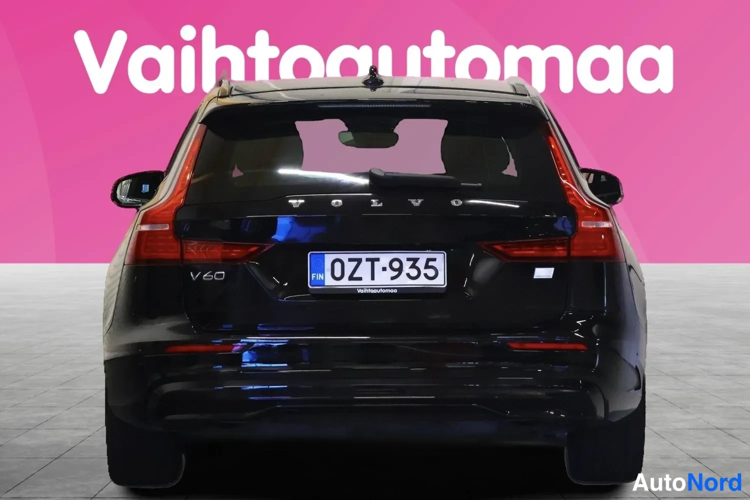Takaa: Musta farmariauto suoraan takaa, VOLVO-merkintä ja rekisteritunnus.