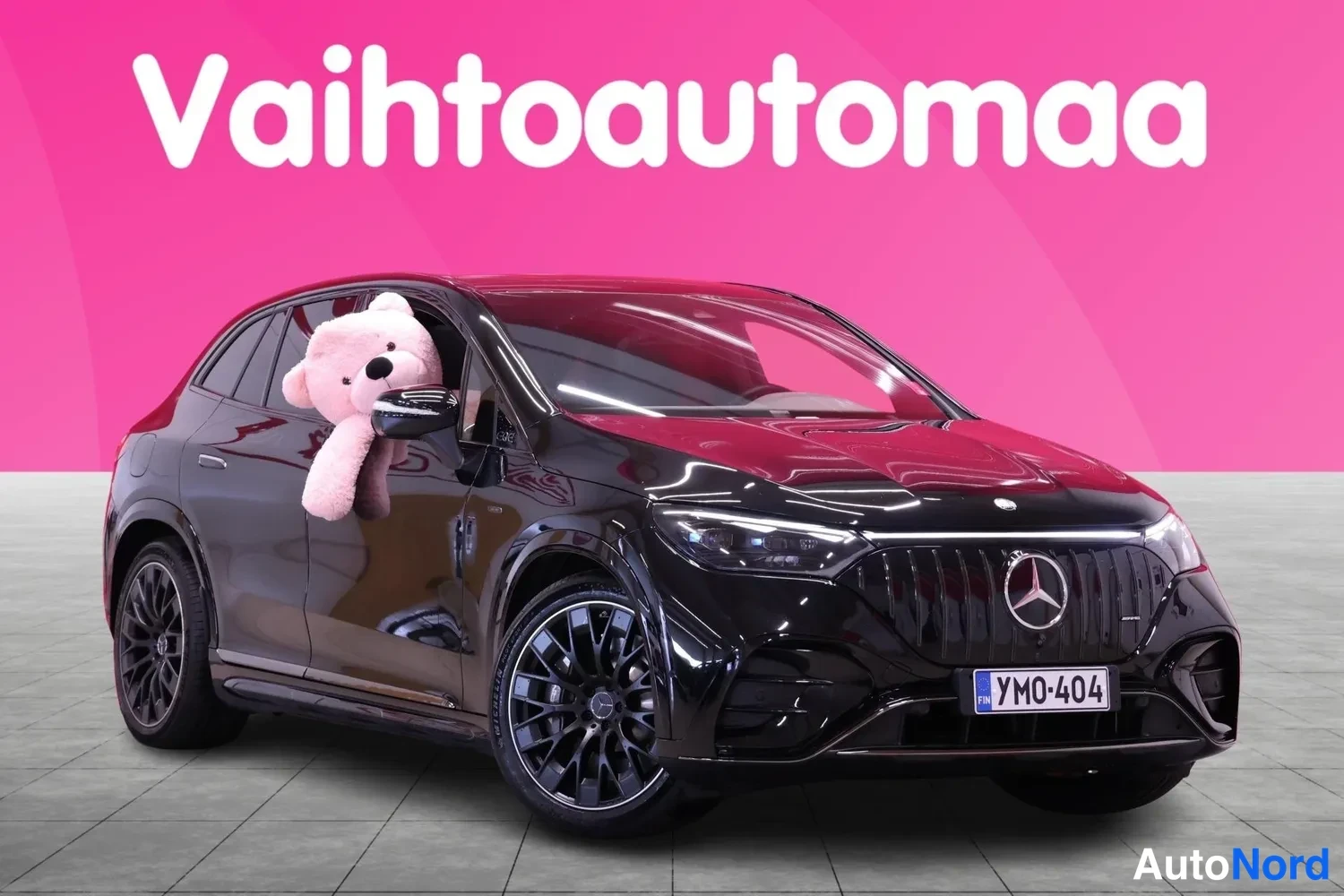Etuviisto, nokka oikealle: Musta Mercedes-Benz-henkilöauto etuviistosta oikealta kuvattuna. Keulassa Mercedes-tähti ja rekisterikilpi, mustat kevytmetallivanteet. Etuikkunasta roik