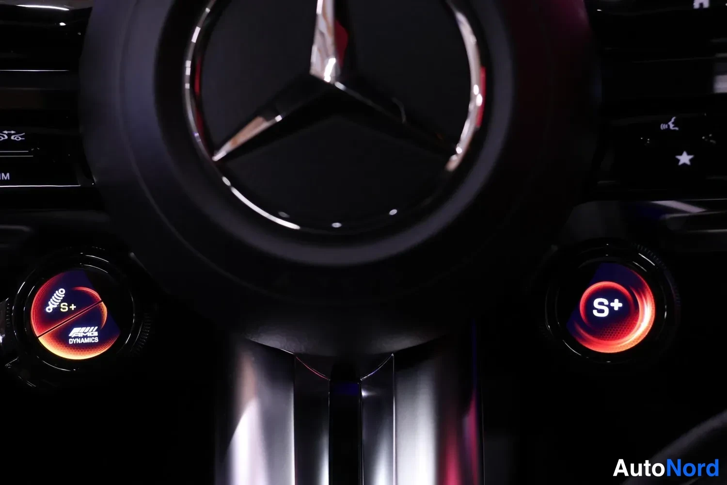 Muu: Ohjauspyörän takana näkyvät siniset AMG DYNAMICS- ja S+-tilan valintapyörät, Mercedes-tähti keskellä.