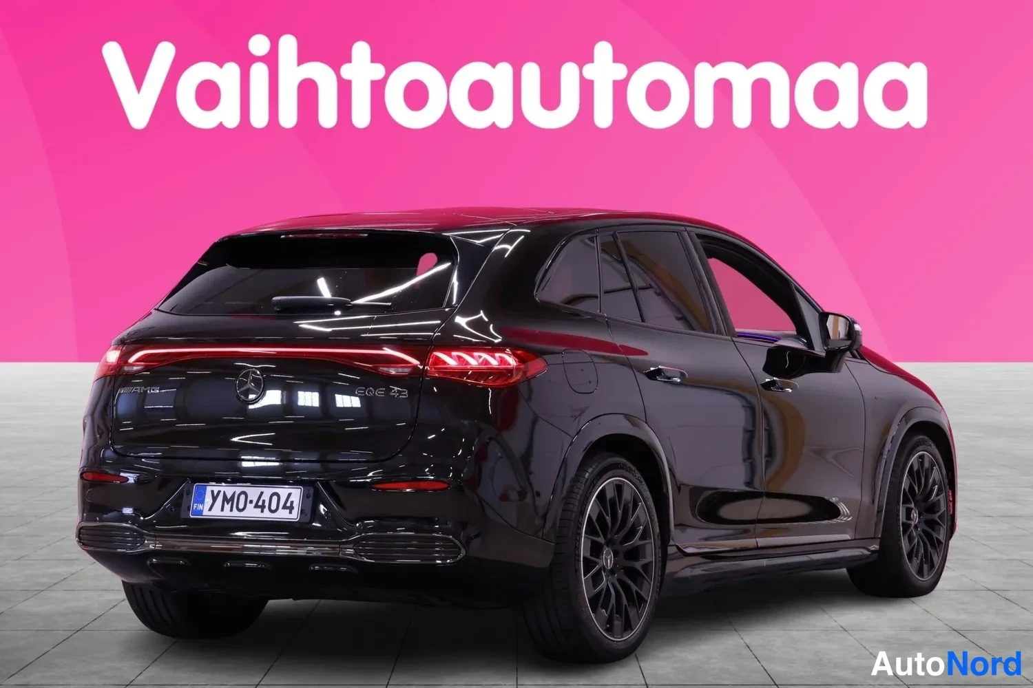 Takaviisto: Musta Mercedes-Benz EQE SUV takaa vasemmalta kuvattuna, rekisteri, pinkki tausta.
