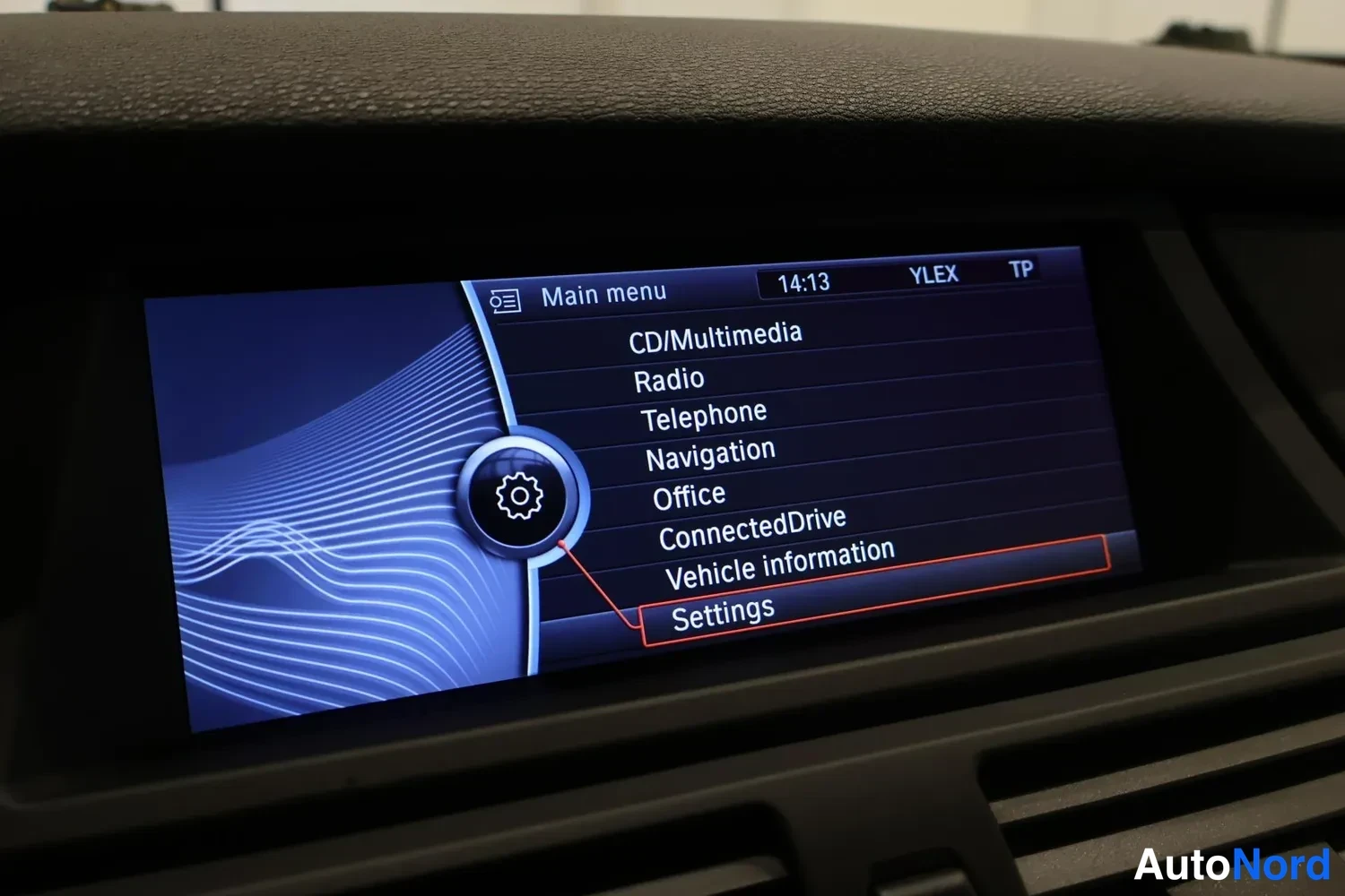 Yksityiskohta: Auton kojelaudan näyttö, jossa Main menu-valikko: CD/Multimedia, Radio, Telephone, Navigation, Office, ConnectedDrive, Vehicle information ja Settings; kellonai