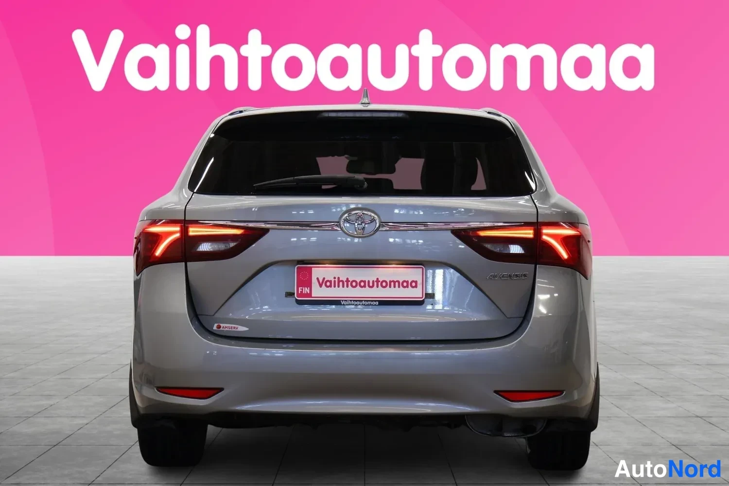 Takaa: Toyota Avensis farmarin takaosa suoraan takaa; Toyota-merkki ja Vahtoautomaa-kilpi takaluukussa.