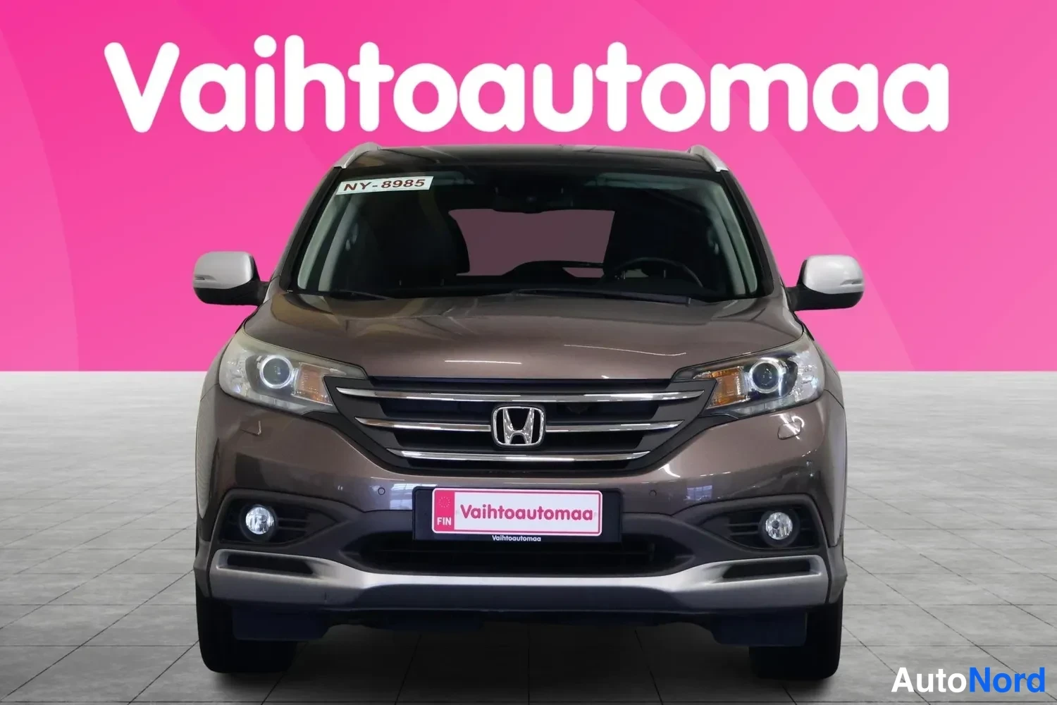 Edestä: Honda CR-V suoraan edestä kuvattuna, pinkki tausta ja valkoiset peilit